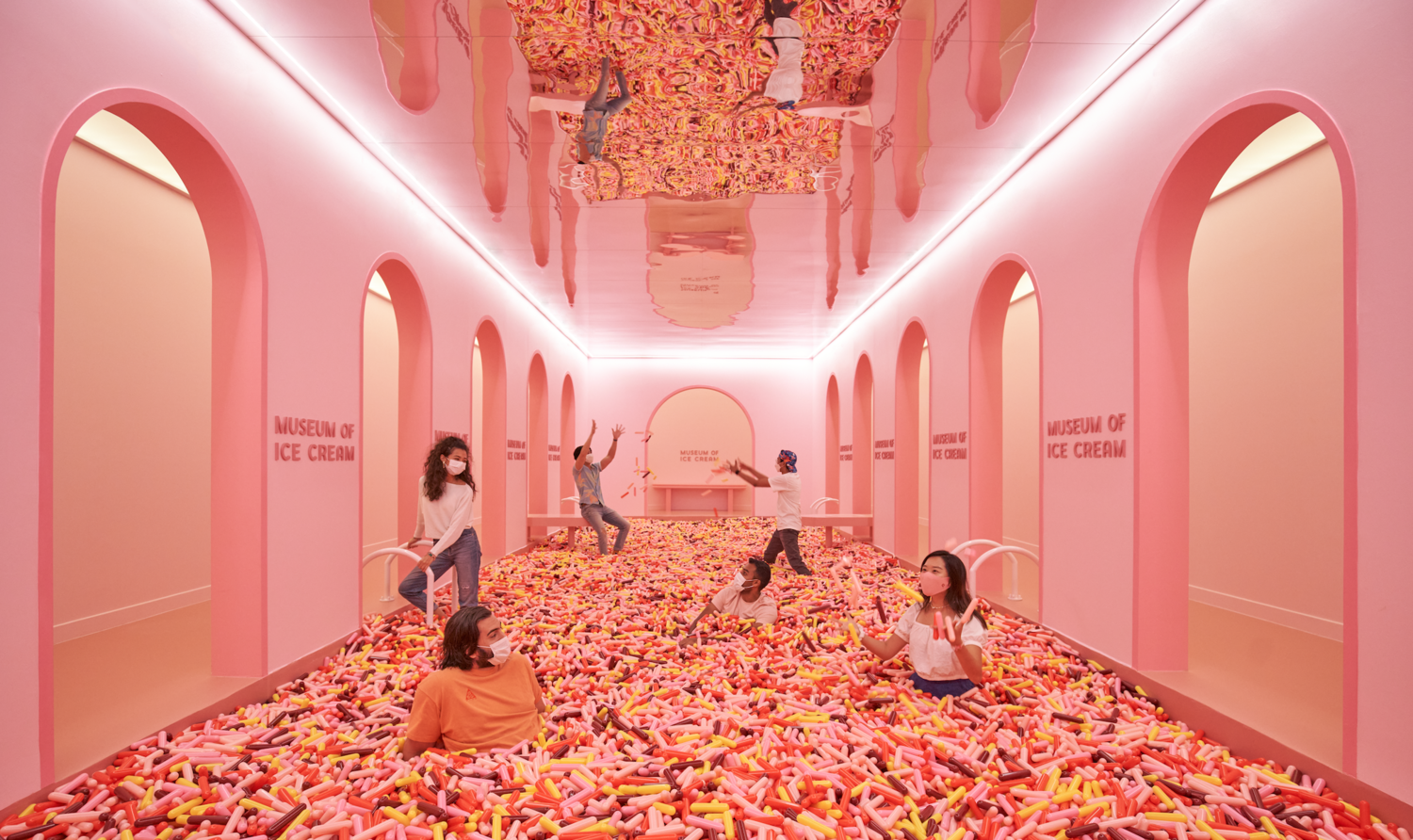 bunch of adults in mask playing sprinkles in a pool at museum of ice cream Singapore