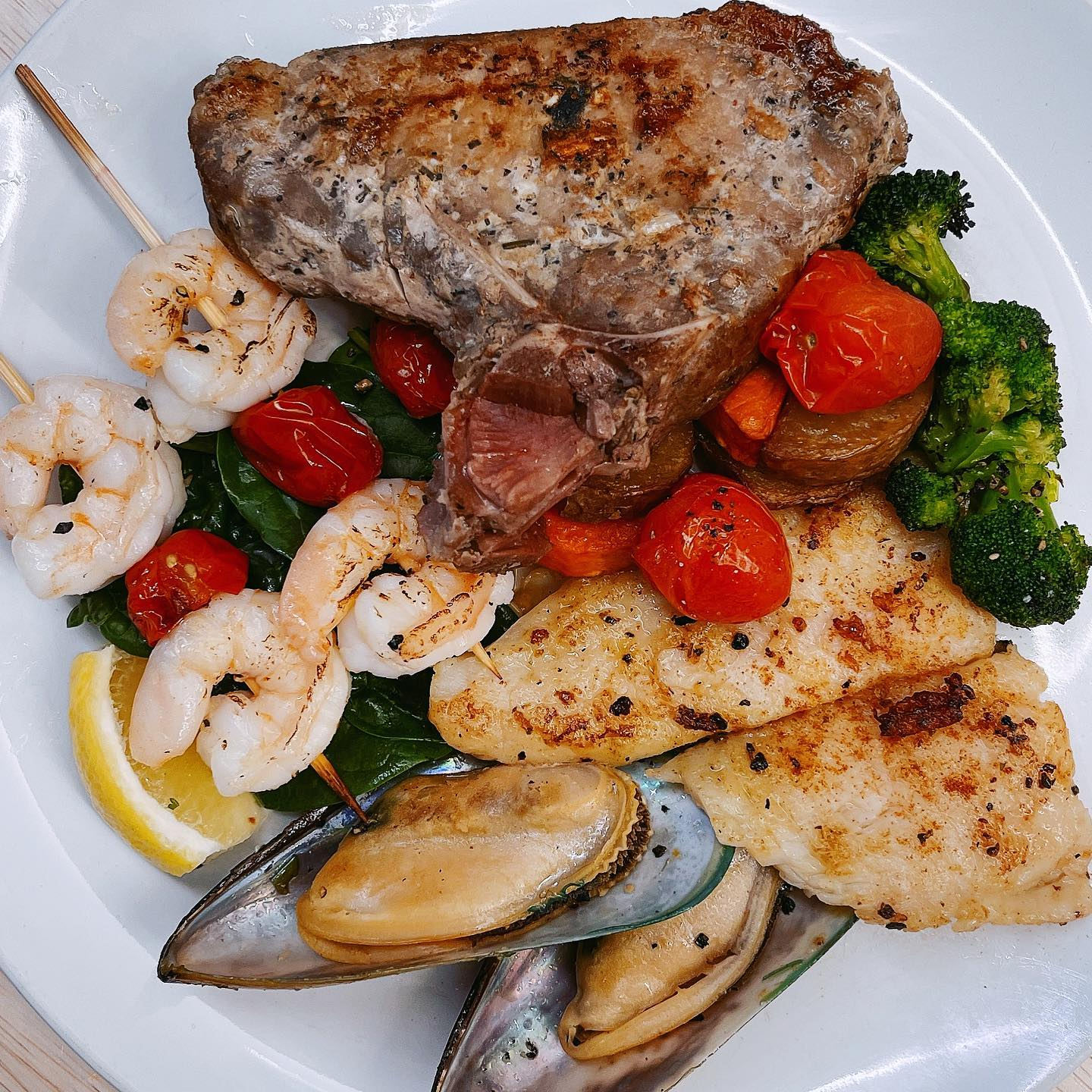 surf and turf - prawns, fish, mussels and beef served with brocolli and cherry tomatoes