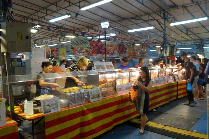 People buy foods in the night market in Singapore. Singapore's night markets have much to offer the discerning traveler