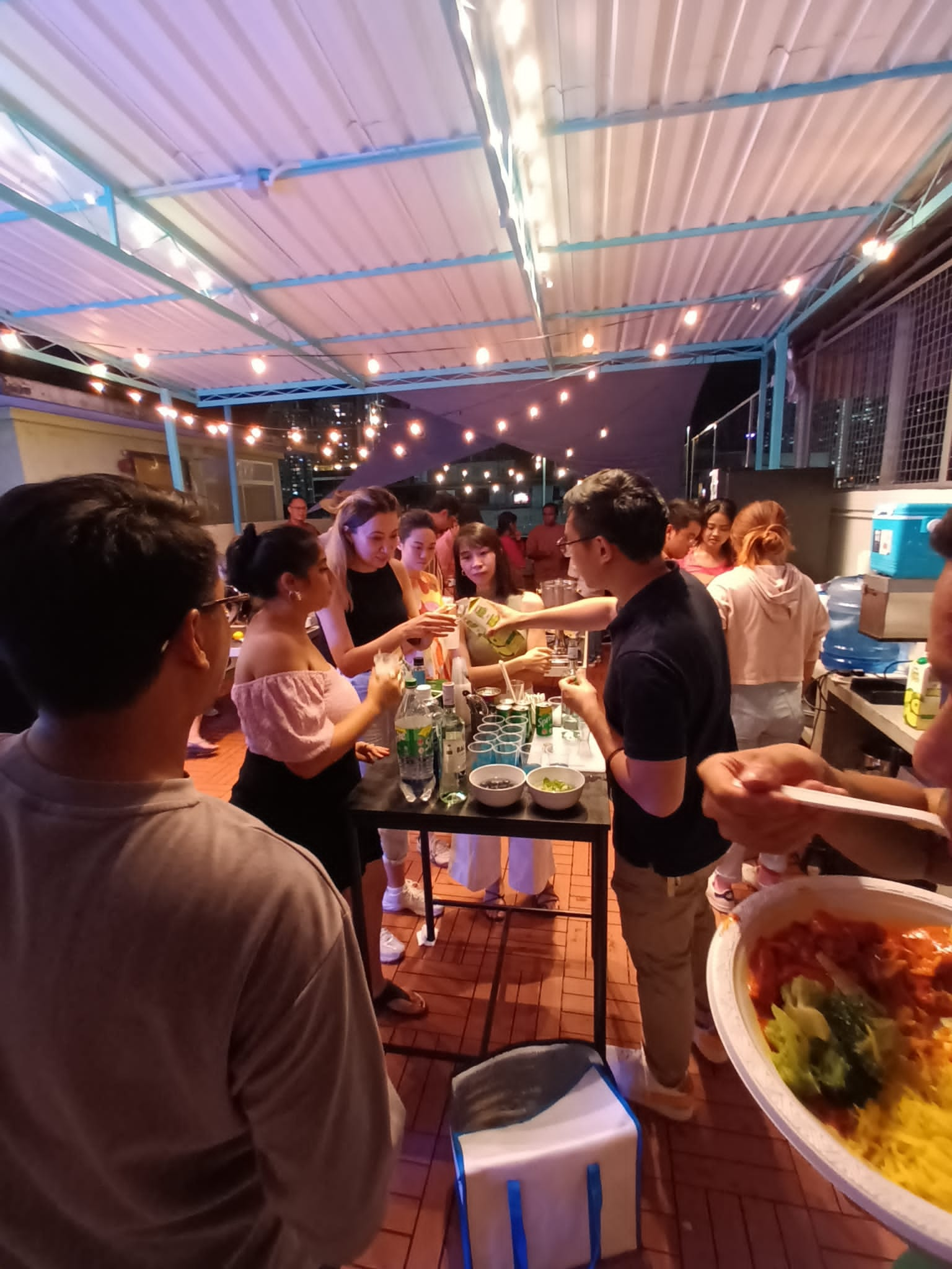 Gavin pouring lime juice for tenants at a rooftop party