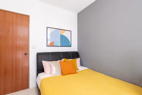 Standard room with a queen bed and a feature wall at The Wisteria in Yishun