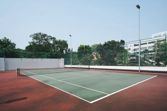 Tennis court surrounded by greenery at Teresa Ville