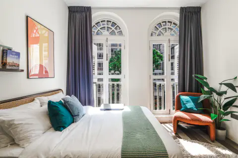 Queen bed under arched windows at Quay 17 by Cove in River Valley