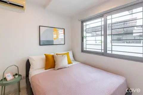 Studio with an orange feature wall and a queen bed at 12A Lorong Salleh